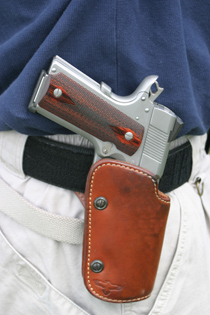 A Colt 1911 pistol riding in a good quality level-one belt handgun holster for personal defense